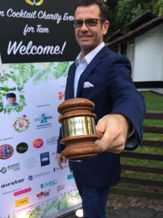 Gavel in hand at a charity cocktail event